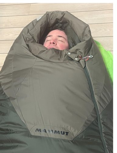 Kunde macht Probeliegen in Mammut Tyin Schlafsack
